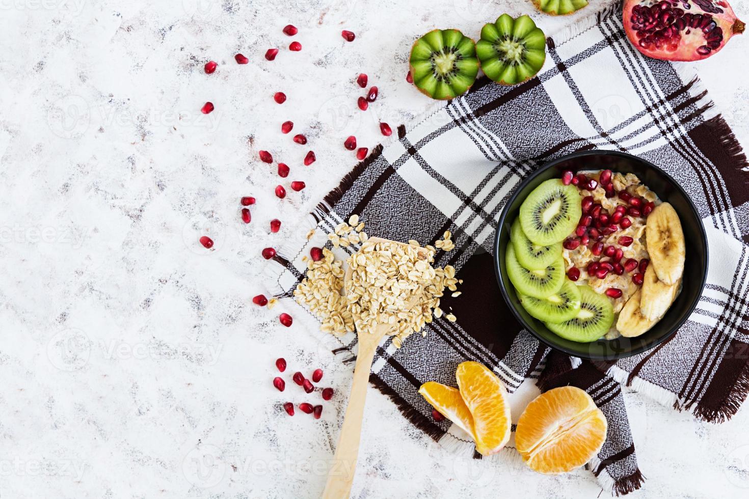 Healthy breakfast oatmeal with fruit on white background top view photo